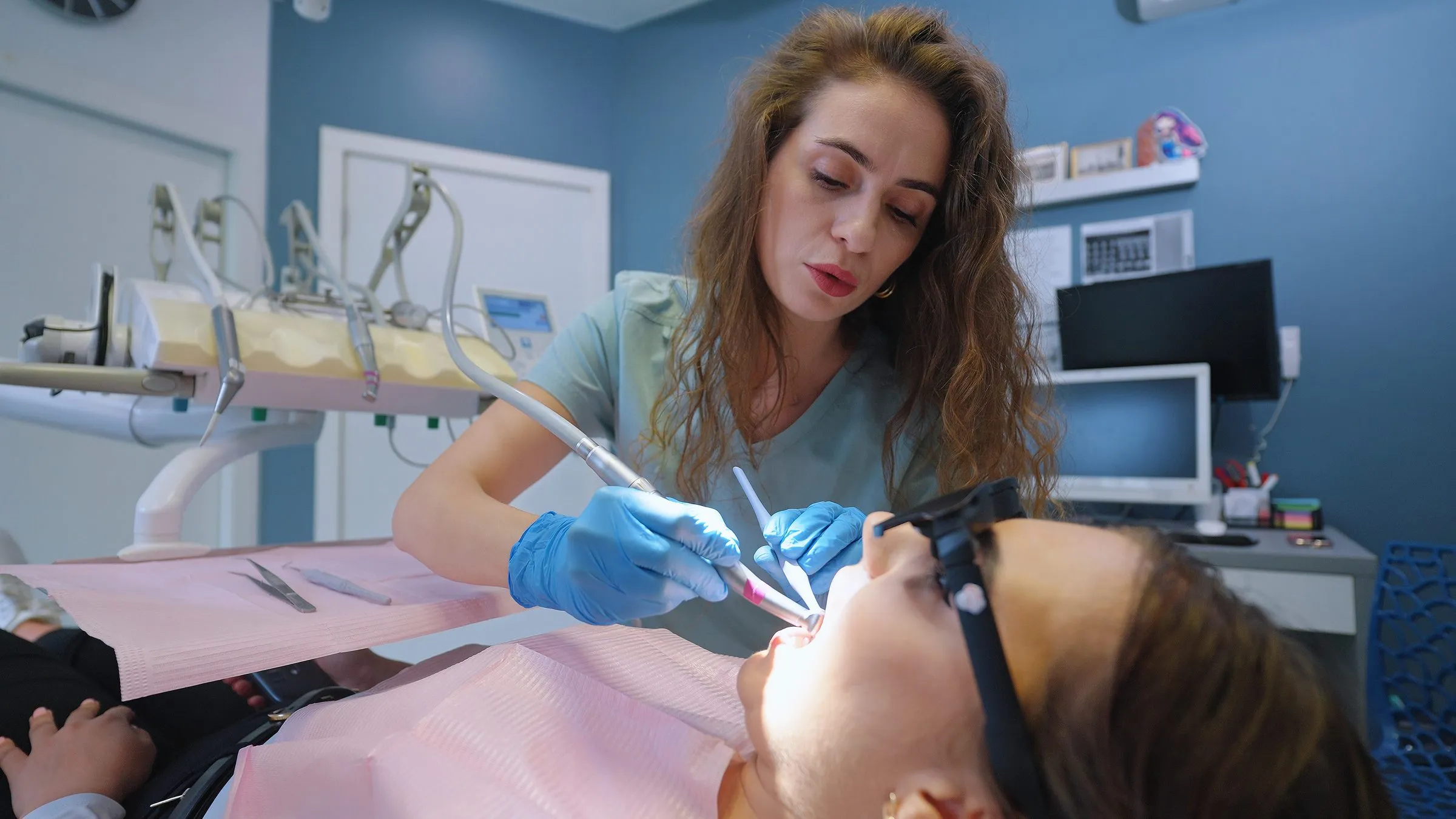 Lekarka leczy pacjentkę, która ma na sobie okulary z ekranem Dental Glasses
